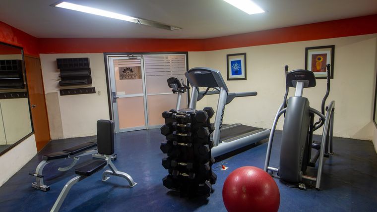 Gimnasio con caminadora, elíptica y mancuernas